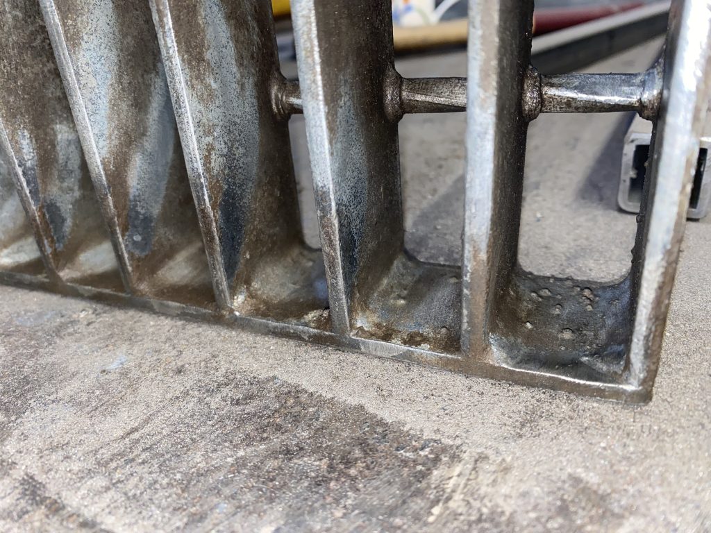 The old and original welds on this steel metal grate panel provided by manufacturer are located only on one side of bearing bar and they do not cover the top of bearing bar. Please notice the rather small size of these welds. JW Investrade Inc. for metalgrating.ca 2023 London Ontario