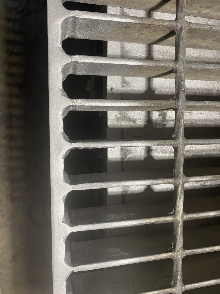 Our large fillet antivibration welds are placed on both sides of each bearing bar as it is visible on the top view image of steel metal grate panel. JW Investrade Inc. for metalgrating.ca 2023, London, Ontario.