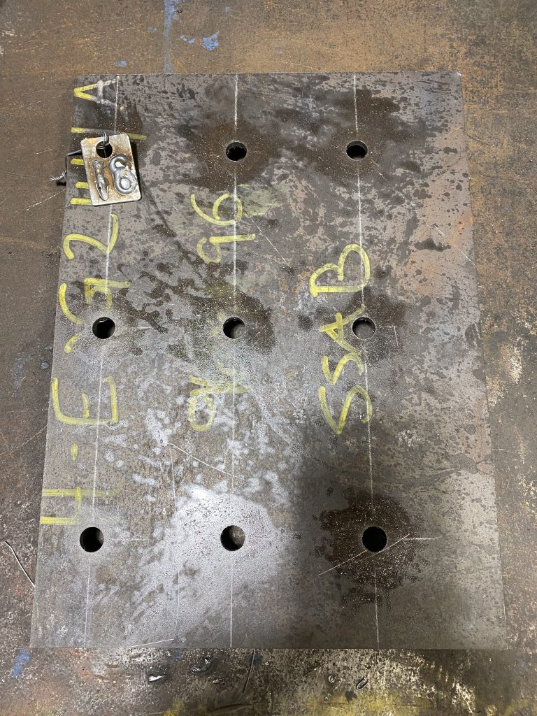 Top view of 7 bearing bars drain cover for rectangular drain with steel angle support. The right side of the floor drain cover does not have any holes since this side of the cover will support the heavy structure on top. JW Investrade Inc. for metalgrating.ca 2023, London Ontario