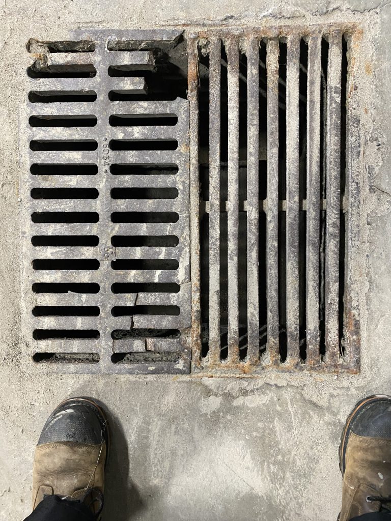 Damaged supported style casted drain cover that is falling apart. Cracks in castings are visible. For JW Investrade Inc. www.metalgrating.ca, London Ontario, 2024
