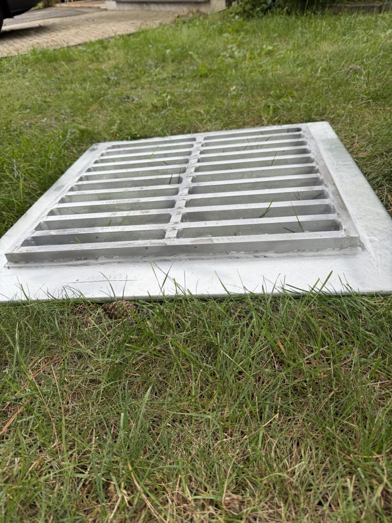 The upside down and angular view of unsupported style custom basin lid exposes steel plate's support, custom steel grating, welded to the steel plate. the height of the support is 1". The flanges of steel plate not cover by steel grating allow for hanging effect of this lid. For JW Investrade Inc.www.metalgrating.ca, London, Ontario. 2026