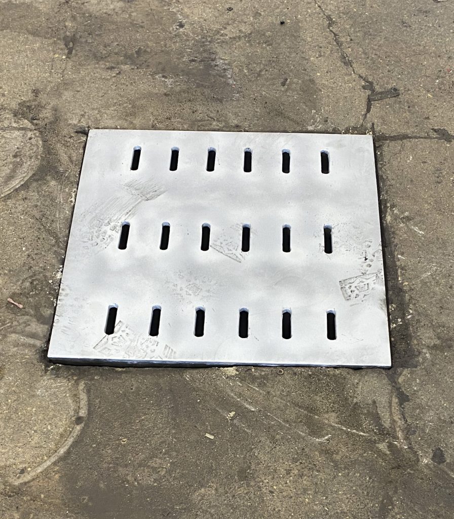Our heavy duty floor drain covers in supported style support well heavy static loads of semi truck with relatively low dynamic impact. Here is A heavy duty floor drain cover in supported style on the garage floor of semi truck mechanical shop. JW Investrade Inc. for Metalgrating.ca , 2024, London
