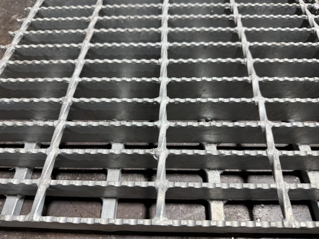 At Metalgrating.ca we weld cross bars under the load bearing bars to protect them against twisting that leads to breaking. In this way we mimic much more expensive swagged grating. Twisting of load bearing bars is a second stage after bowing in the destruction process of heavy duty grating. Cross bars at the bottom join the bottom of load bearing bars and eliminate risk of twisting for specific bars. JW Investrade Inc. for metalgrating.ca, 2026, Lucan Ontario